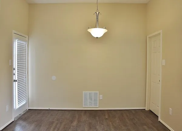 a view of a room with a ceiling fan and wooden floor