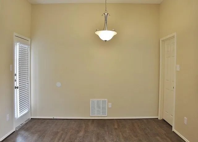 a view of a room with a ceiling fan and wooden floor