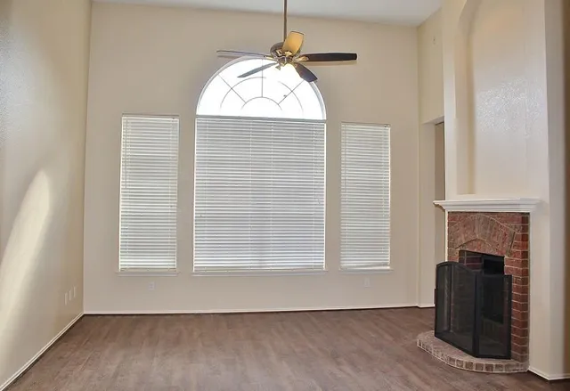 an empty room with windows and fireplace