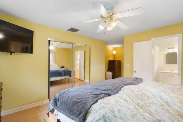 a spacious bedroom with a bed and a chandelier