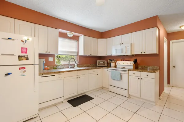a kitchen with a refrigerator and a stove top oven