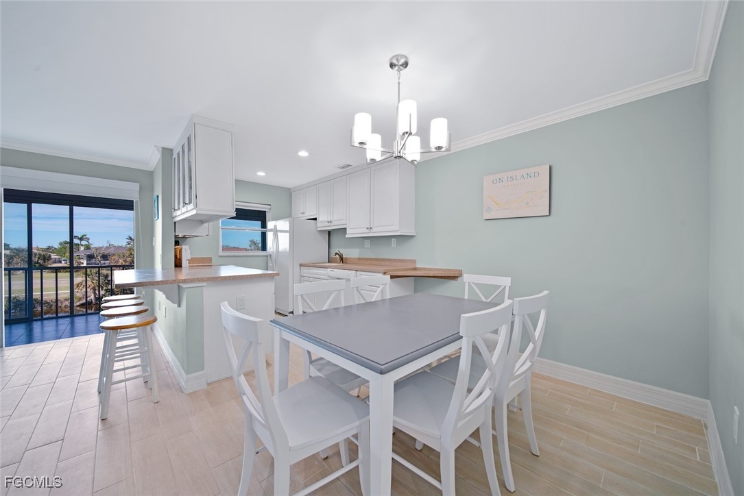 1610 Middle Gulf Drive, Unit D5 Sanibel, FL 33957 - Photo 26 of 47 a view of a dining room with furniture wooden floor and a chandelier