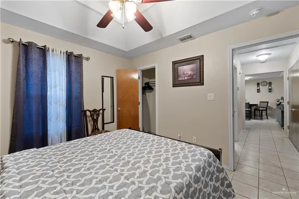 a bedroom with a large bed chandelier and a window