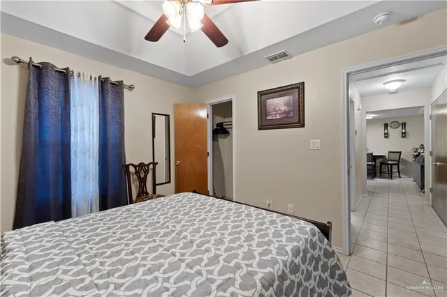 a bedroom with a large bed chandelier and a window