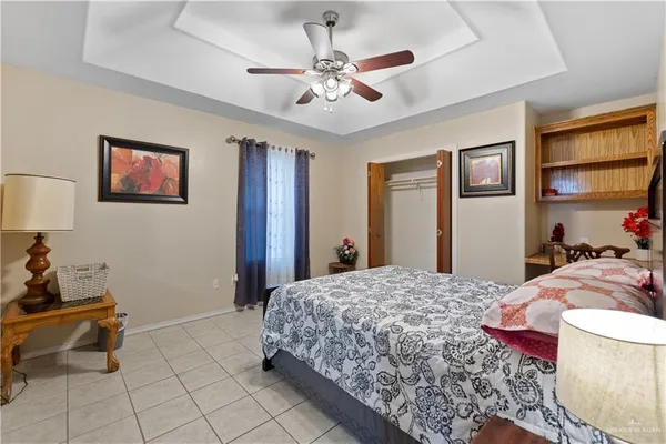 a bedroom with a large bed and a chandelier
