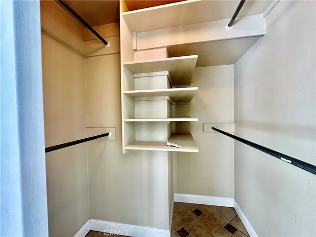 a view of walk in closet with empty racks