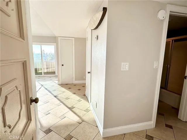 a view of a hallway with wooden floor and a living room
