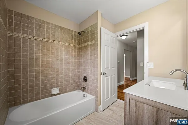 a bathroom with a sink a mirror a bathtub and shower