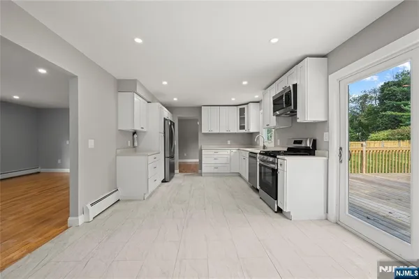 a kitchen with white cabinets and white appliances