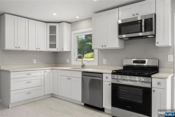 a kitchen with cabinets stainless steel appliances and wooden cabinets