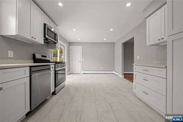 a kitchen with granite countertop white cabinets and appliances