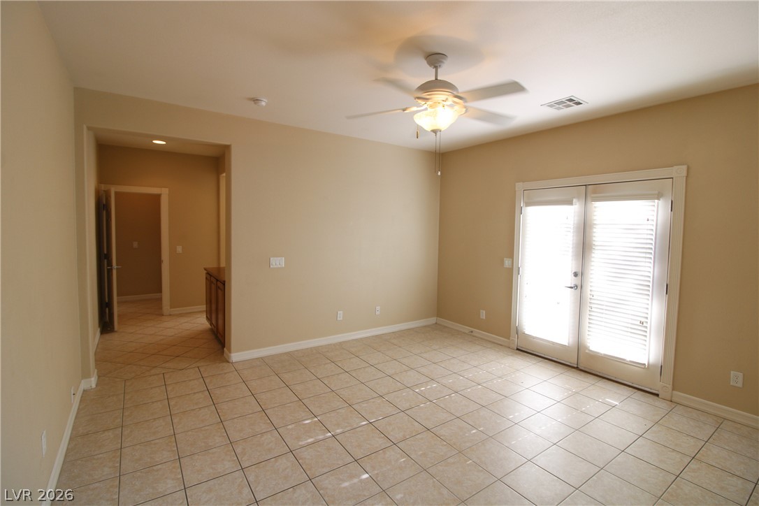 754 Rise Canyon Drive Henderson, NV 89052 - Photo 20 of 34 An inviting room with sleek tile flooring extends to a doorway with direct outdoor access.