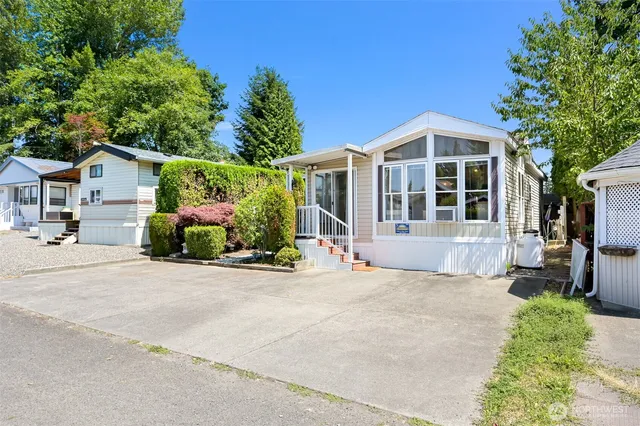 a front view of a house with a yard and potted plants