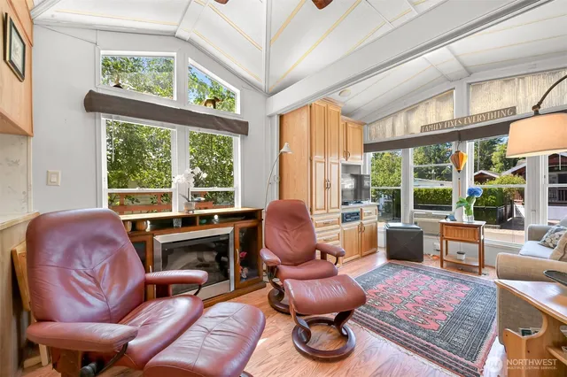 a living room with furniture fireplace and large windows