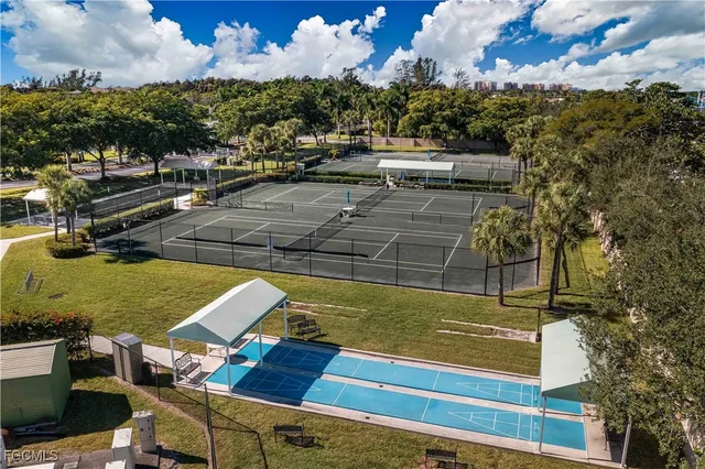 a view of a swimming pool with outdoor seating and trees in the background