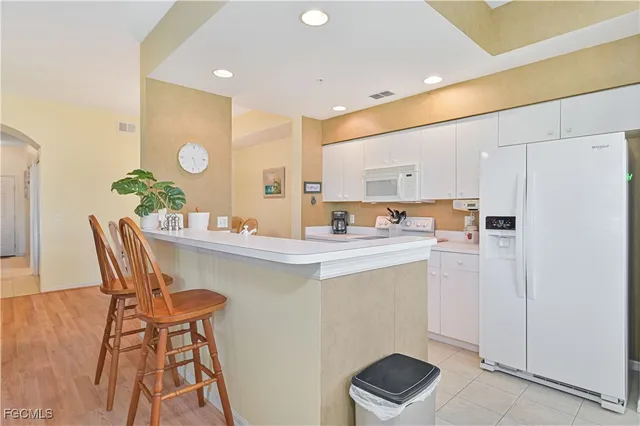 a kitchen with a dining table chairs and a refrigerator