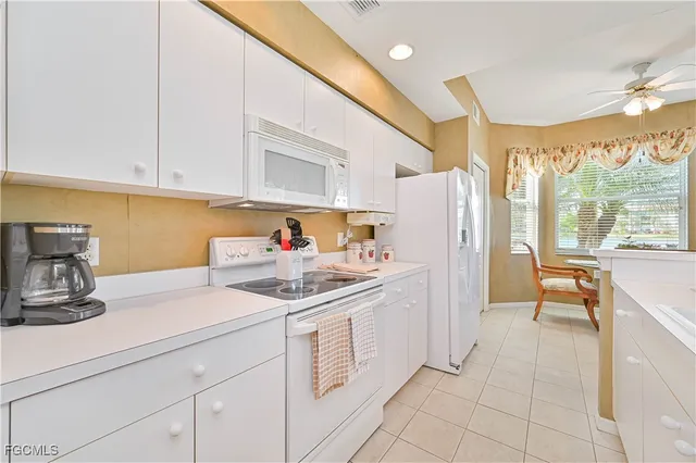 a kitchen with a sink a stove and white cabinets