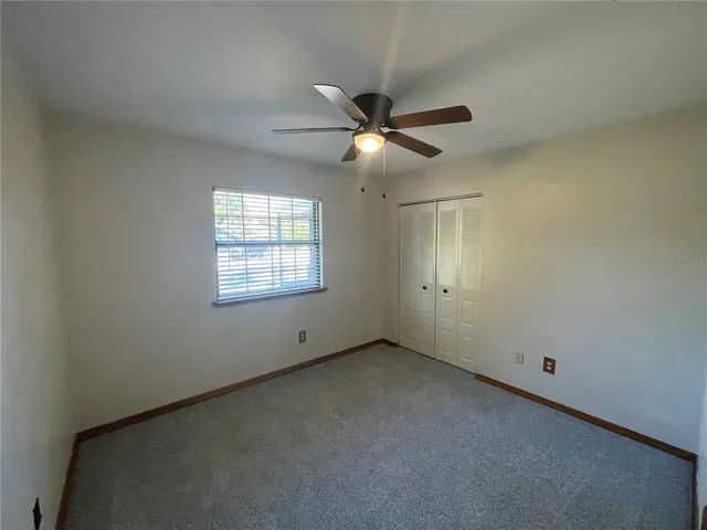 an empty room with a window and a fan