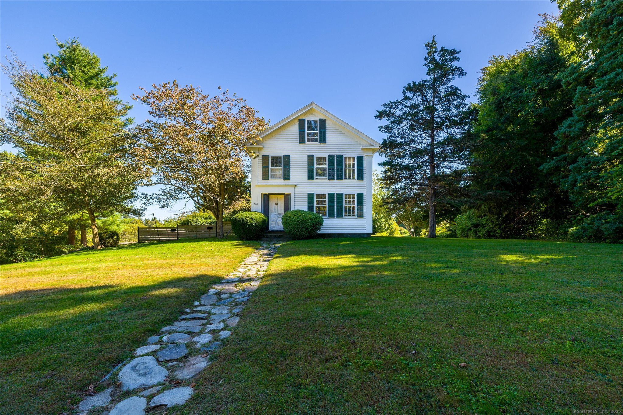 a view of a house with a big yard and large trees