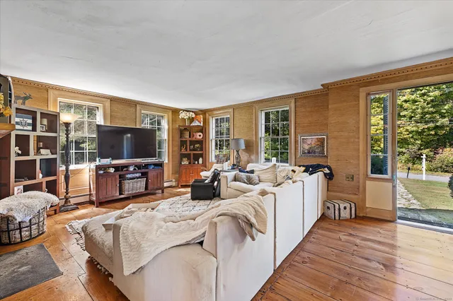 a living room with furniture a flat screen tv and a floor to ceiling window