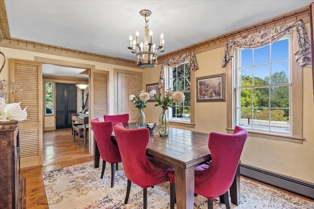 a view of a dining room with furniture a chandelier and wooden floor