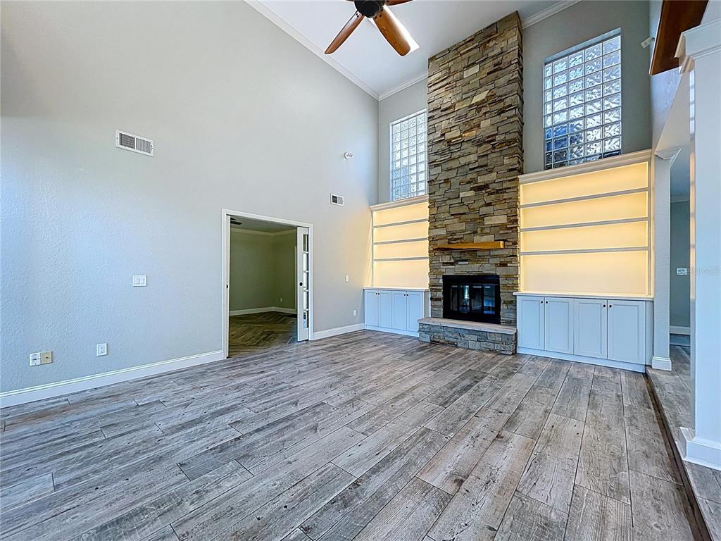 10655 Lakeview Drive New Port Richey, FL 34654 - Photo 12 of 83 a view of empty room with wooden floor and fireplace