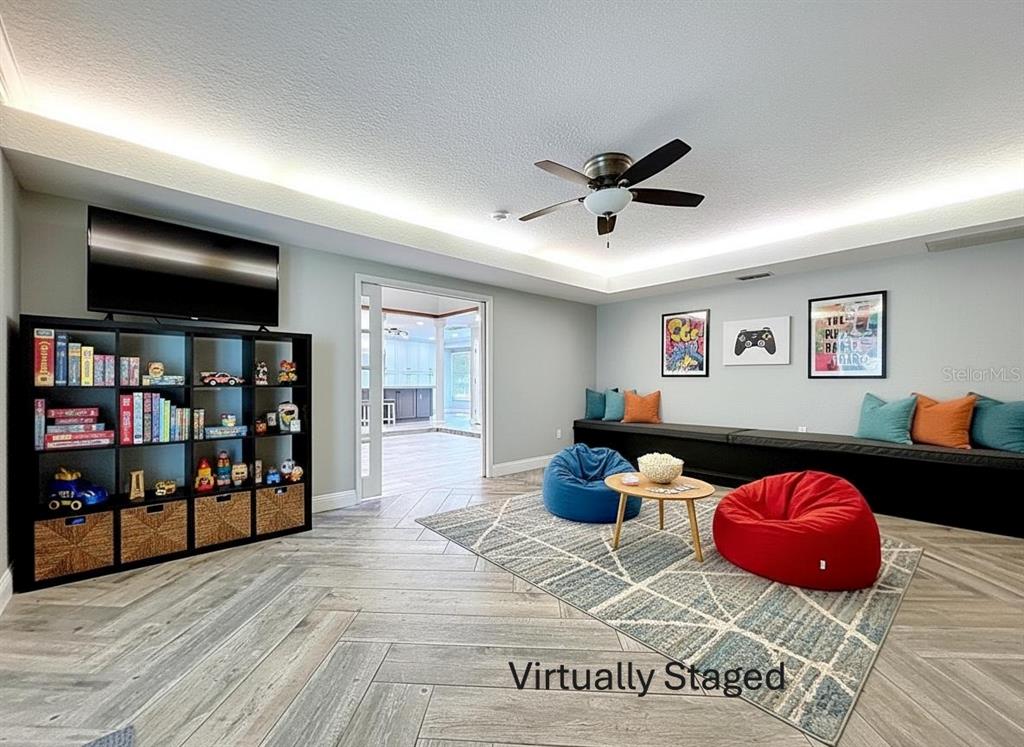 10655 Lakeview Drive New Port Richey, FL 34654 - Photo 26 of 83 a living room with furniture a flat screen tv and a book shelf