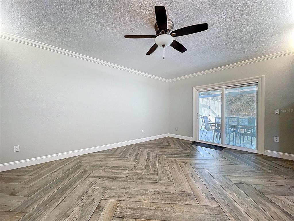 10655 Lakeview Drive New Port Richey, FL 34654 - Photo 28 of 83 a view of empty room with wooden floor and fan