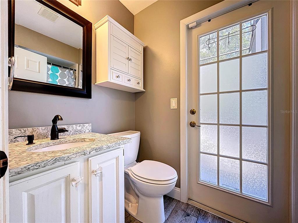 10655 Lakeview Drive New Port Richey, FL 34654 - Photo 30 of 83 a bathroom with a granite countertop toilet sink and mirror