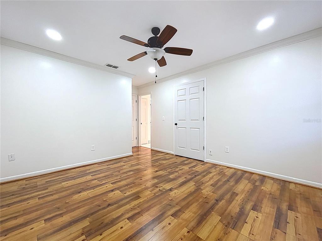 10655 Lakeview Drive New Port Richey, FL 34654 - Photo 49 of 83 an empty room with wooden floor and a ceiling fan