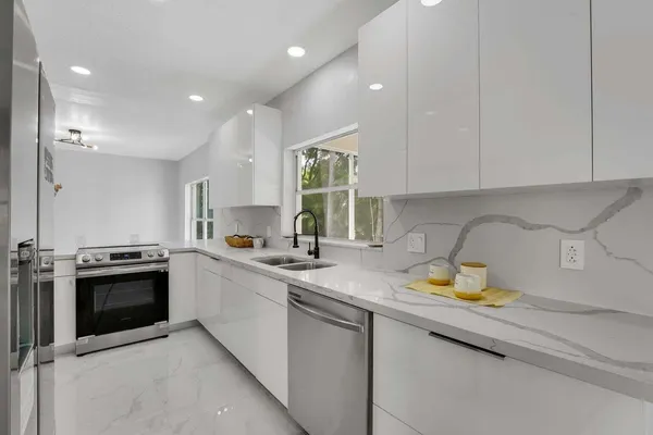 a kitchen with stainless steel appliances granite countertop a sink stove and cabinets