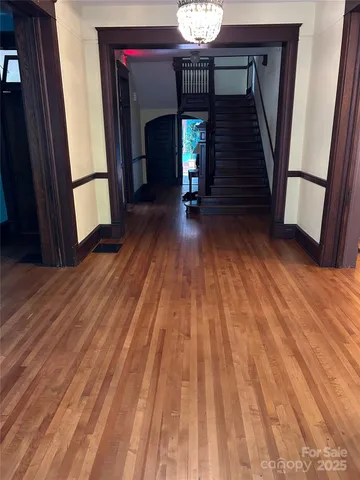 a view of a hallway with wooden floor and staircase