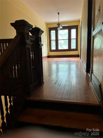 a view of empty room with wooden floor and windows
