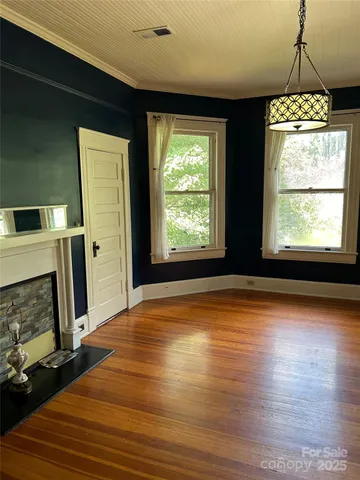 a view of empty room with wooden floor and fireplace