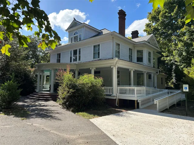 a front view of house with yard and trees around