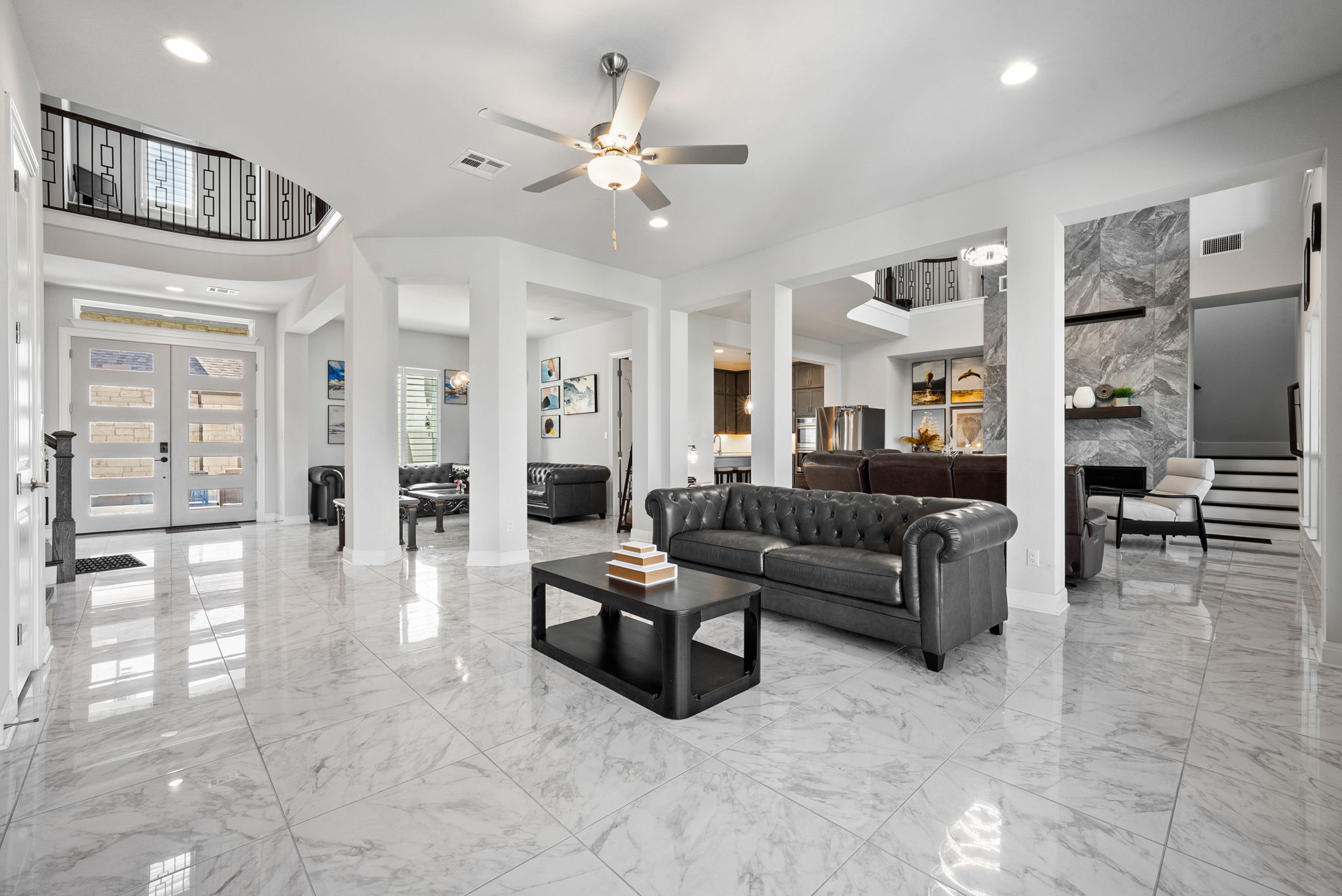 2132 Novara Trail Leander, TX 78641 - Photo 22 of 40 Living room featuring french doors, a fireplace, a ceiling fan, recessed lighting, and light marble finish floors