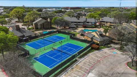 a view of a tennis ground with a table and chairs