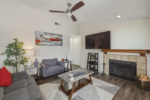 a living room with furniture a fireplace and a flat screen tv