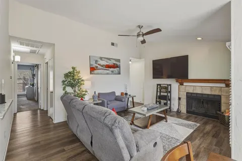 a living room with furniture a fireplace and a flat screen tv