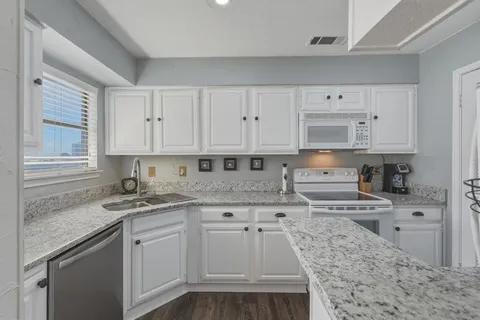 a kitchen with stainless steel appliances granite countertop a sink stove and cabinets