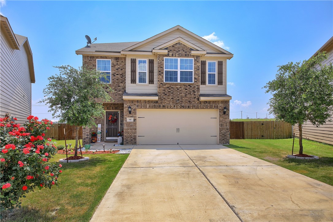 147 Millers Loop Jarrell, TX 76537 - Photo 1 of 1 a front view of a house with a yard and garage