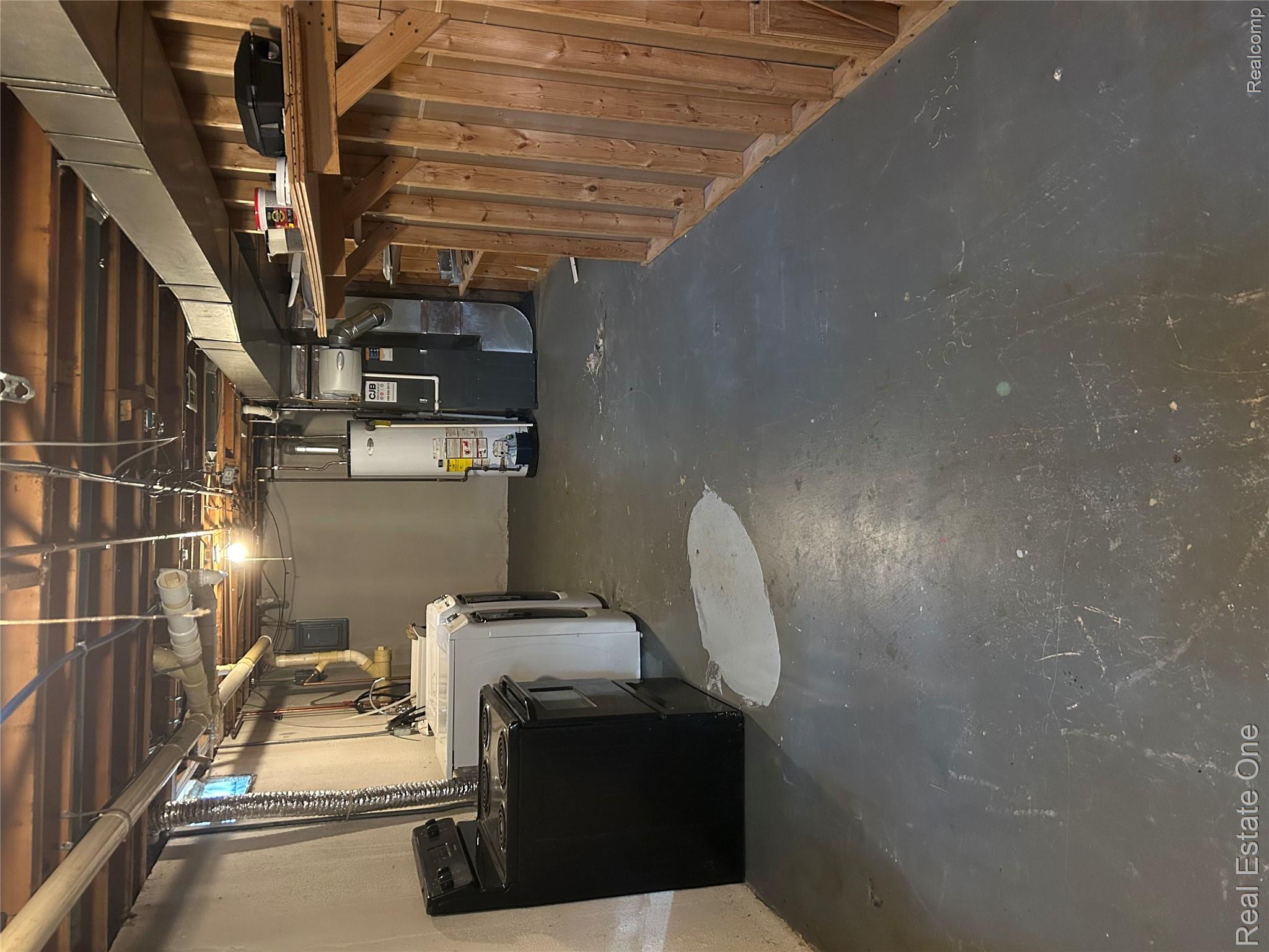 2659 Benstein Road Commerce Township, MI 48382 - Photo 19 of 26 Utility area featuring exposed ceiling joists, concrete flooring, and a wall of unfinished wood paneling