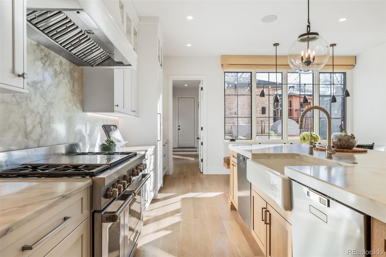 1026 South High Street Denver, CO 80209 - Photo 13 of 50 a kitchen with kitchen island granite countertop a sink stove and cabinets