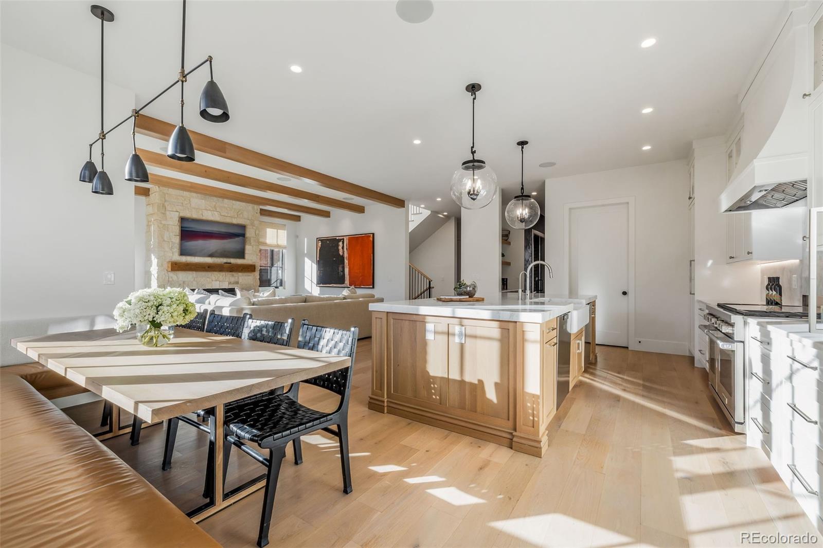 1026 South High Street Denver, CO 80209 - Photo 16 of 50 a kitchen with granite countertop a table chairs stove a sink and a stove