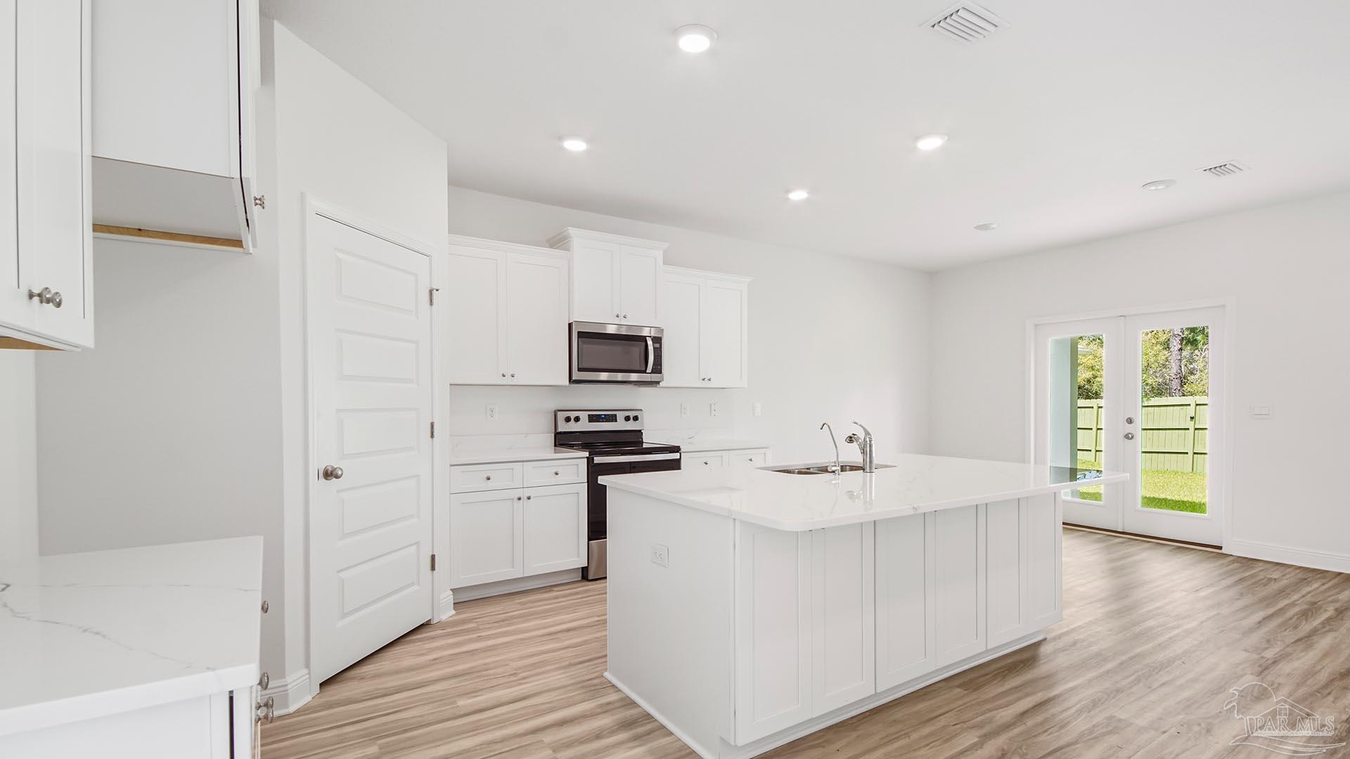 3233 Harrier Road Pace, FL 32571 - Photo 42 of 50 a kitchen with stainless steel appliances granite countertop a sink stove and refrigerator