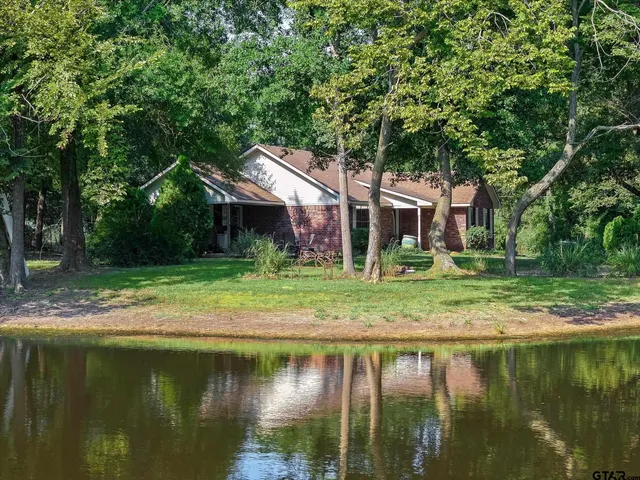 a view of a house with a yard from a lake view