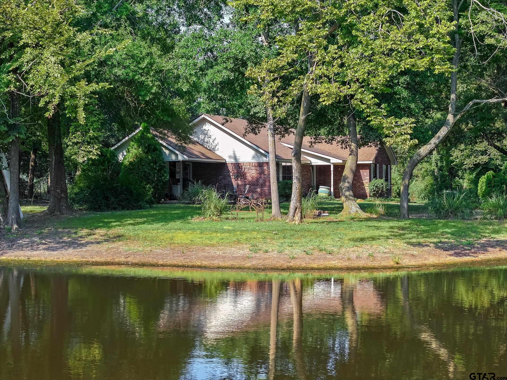 a view of a house with a yard from a lake view