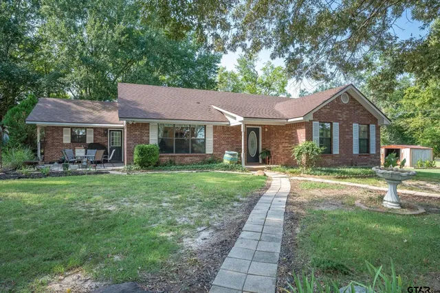 a front view of a house with a yard and green space