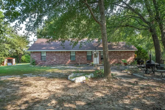 a view of backyard with table and chairs and wooden fence