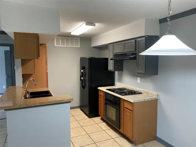 a kitchen with stainless steel appliances kitchen island a stove and a refrigerator